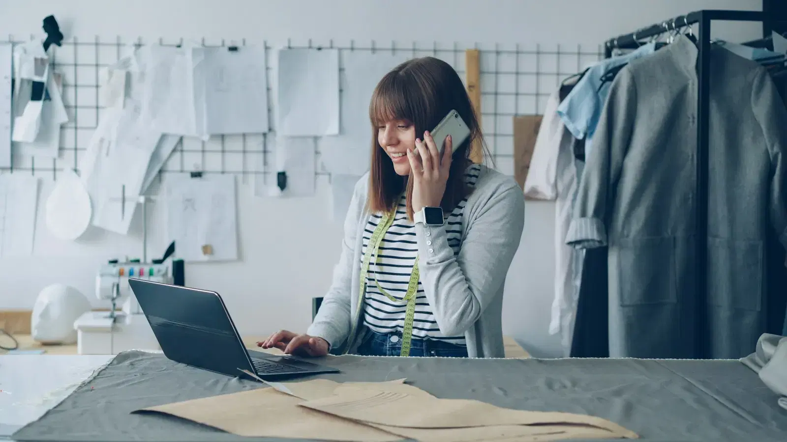 Marketer on a call while drafting a message template on a laptop