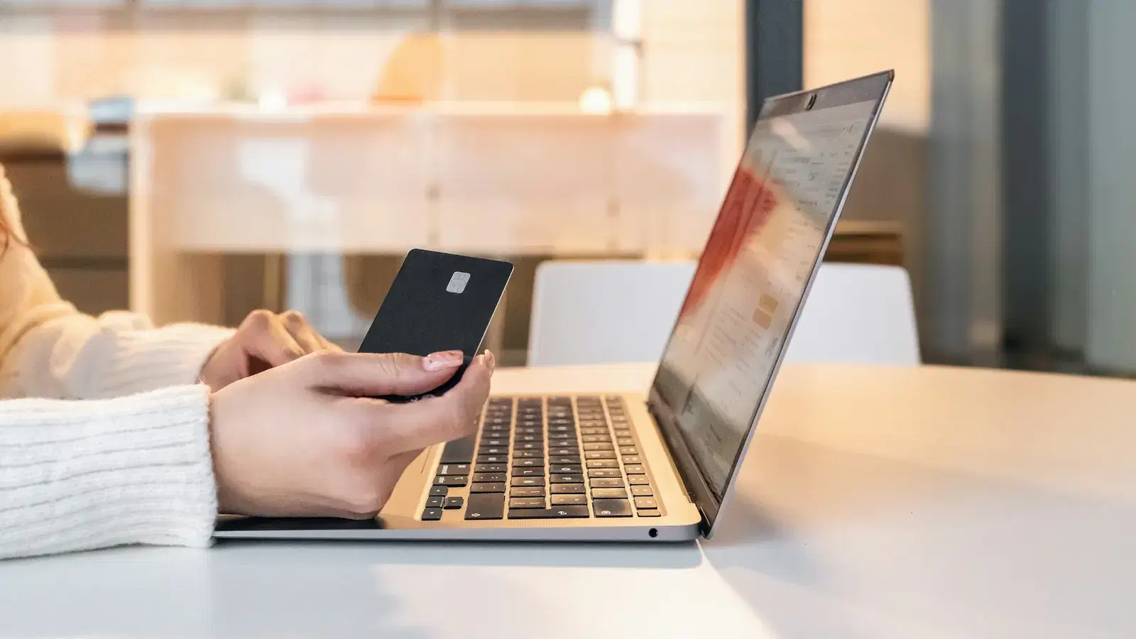 Shopper chatting with a business on her phone while browsing on a laptop